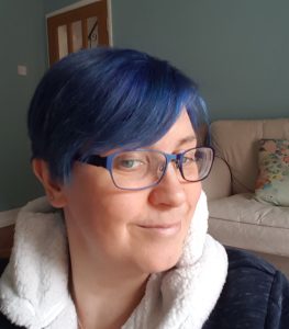 Photo of a woman with glasses and short blue hair